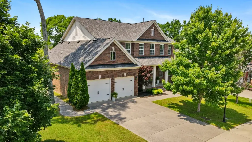 Drone photo of a two-story brick home with pretty lawn in Murfreesboro, Tennessee