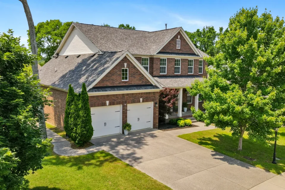 Drone photo of a two-story brick home with pretty lawn in Murfreesboro, Tennessee