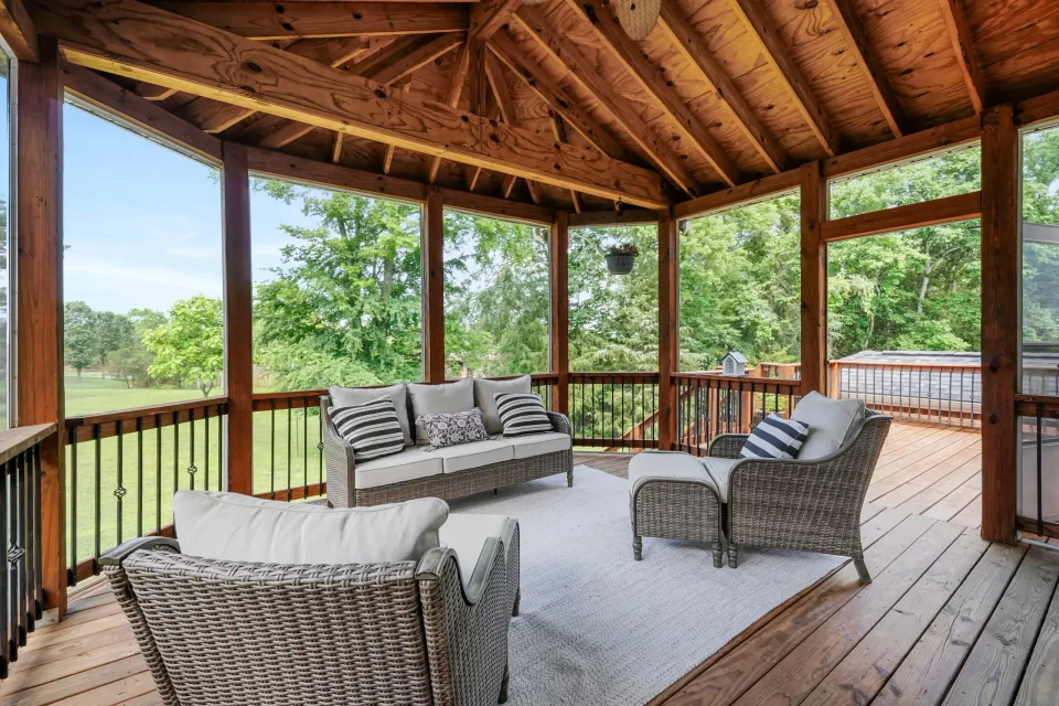 Covered patio with wood-paneled ceiling and outdoor seating overlooking backyard in Murfreesboro home